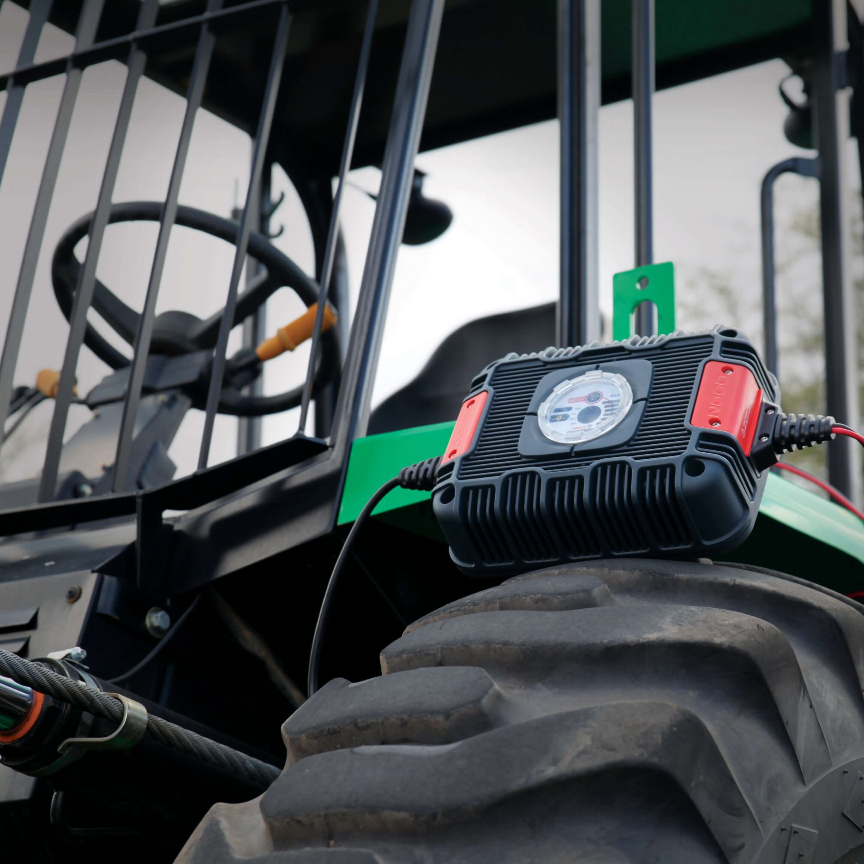 NOCO 24V 40A Industrial Battery Charger on utility vehicle tire at Cabin Depot