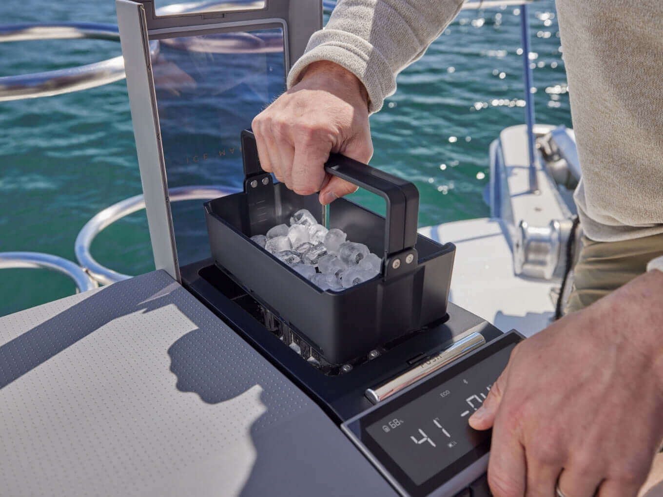 Ice tray being removed from EcoFlow GLACIER 3-In-1 fridge/freezer/ice-maker on a boat. Available at Cabin Depot. Efficient and portable.