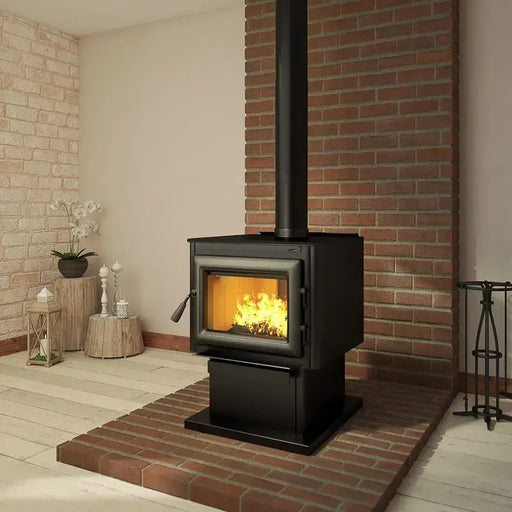 Black matte Imperial 6" telescopic stove pipe installed on a wood stove, extending to ceiling, in a cozy brick-walled room setting.