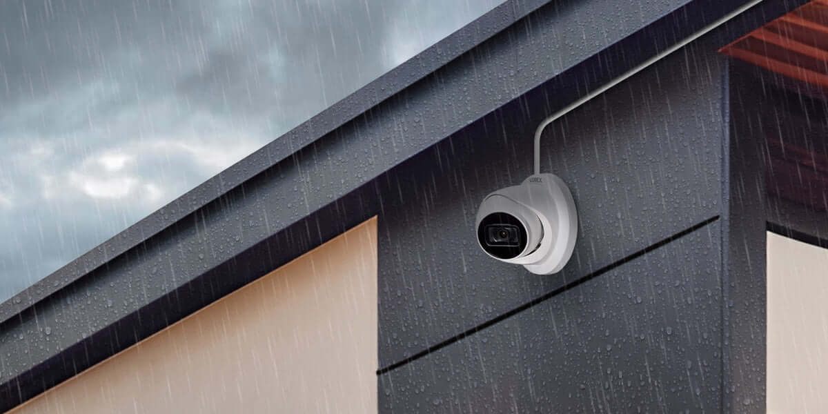 Lorex Fusion 4K Wired Dome IP Camera installed outdoors under rainy weather, available at Cabin Depot.