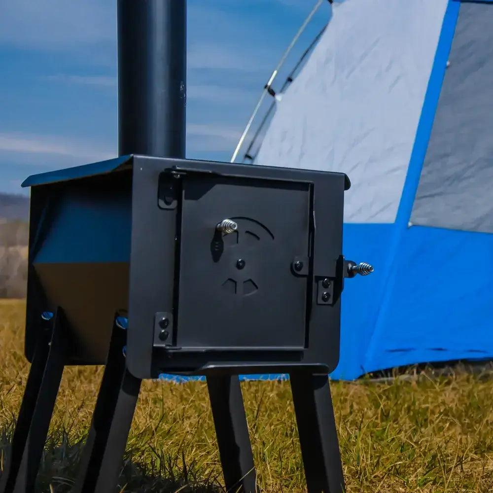 Englander Cub Kit Wood Stove at a campsite, featuring portable design with 12-gauge steel, available at Cabin Depot.