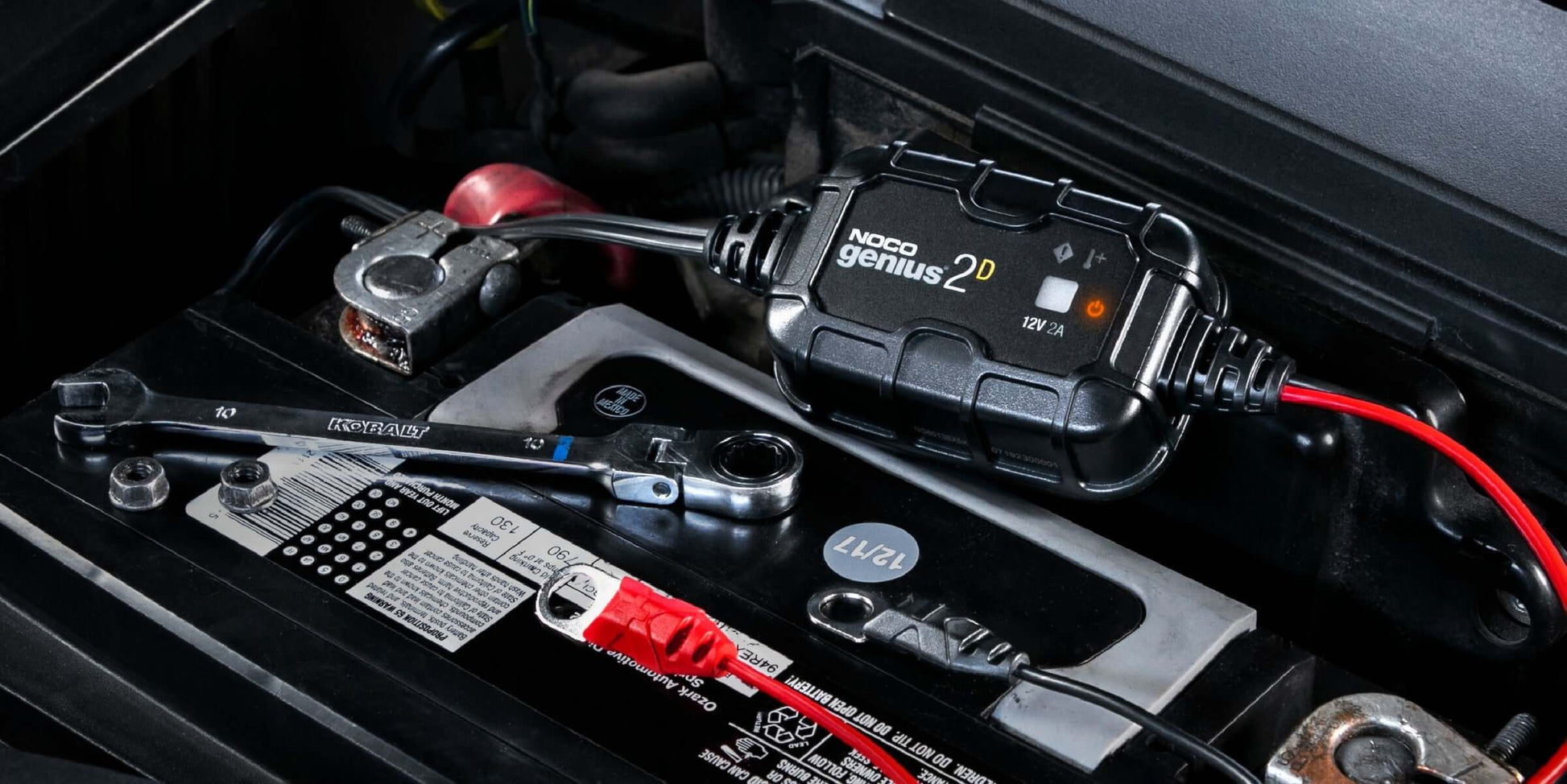NOCO GENIUS2D 2A direct-mount battery charger in action with tools, ideal for 12V lead-acid batteries at Cabin Depot.