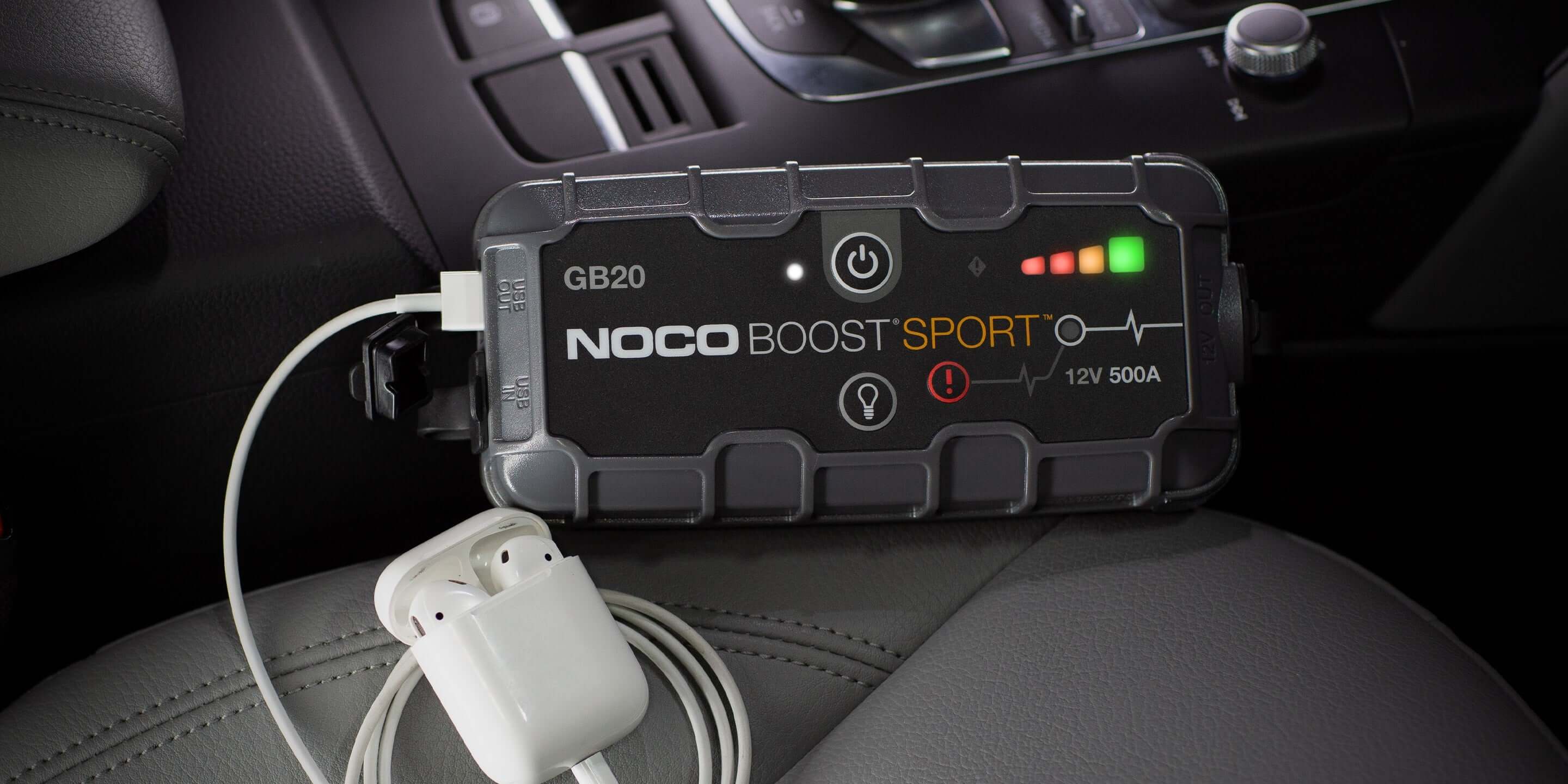NOCO 12V 500A Boost Jump Starter on car seat, featuring USB charging. Available at Cabin Depot. Safe, spark-proof technology.
