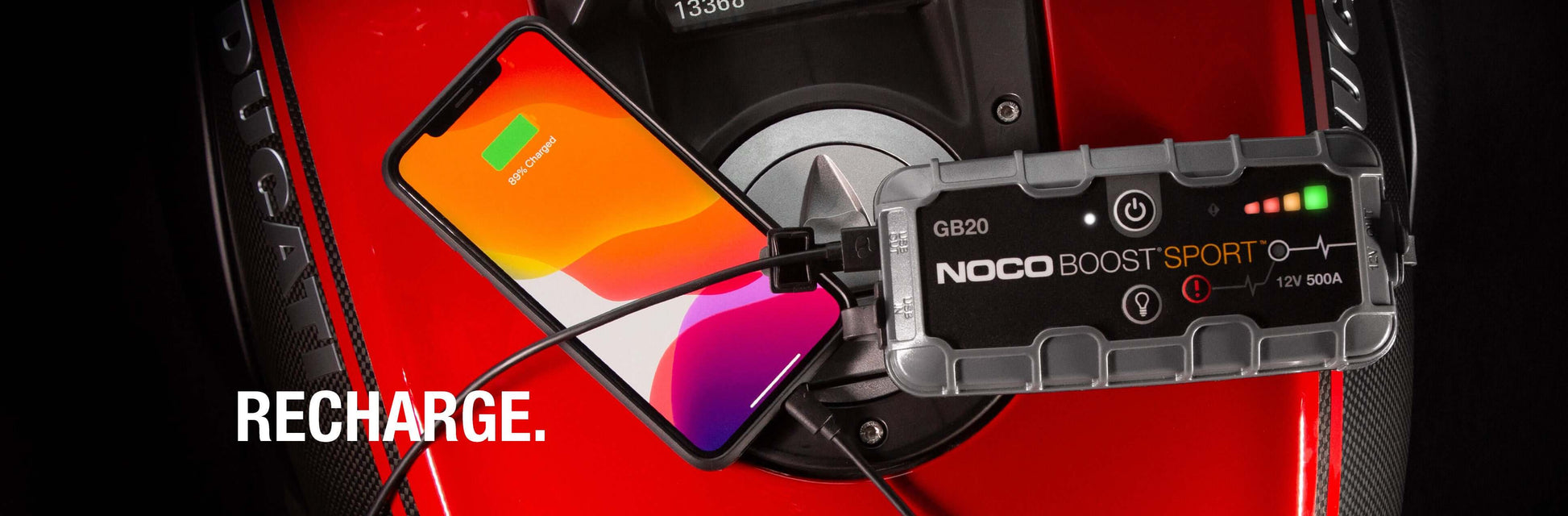 NOCO 12V 500A Boost Jump Starter charging a smartphone, available at Cabin Depot, showcasing portable power and safety features.