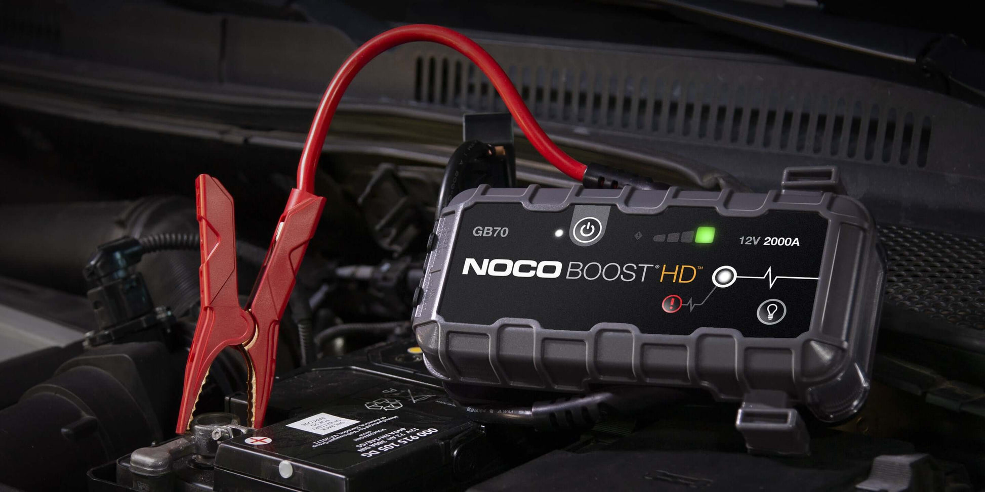 NOCO 12V 2,000A Boost Jump Starter in use on car battery, featuring UltraSafe design and spark-proof technology from Cabin Depot.