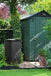 Biolan Biowaste Composter in garden next to green shed, surrounded by lush plants, for eco-friendly waste composting and odorless use.