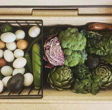 Canyon Coolers 55QT Outfitter Basket with fresh produce and eggs, ideal for organized storage at Cabin Depot.