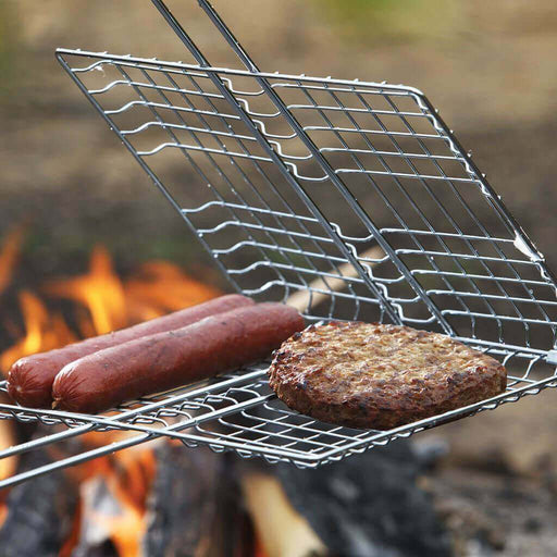 Chrome-plated Coghlans Broiler with locking ring grilling sausages and burger over open fire, ideal for BBQ and camping.