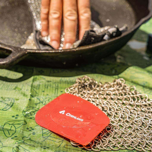 Cleaning cast iron pan with Coghlan's chainmail scrub pad and scraper.