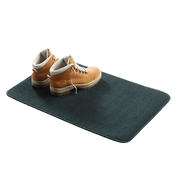 Outdoor mat with hiking boots, showcasing the durable Coghlans Inside/Outside Mat with non-skid backing and mold-resistant material.