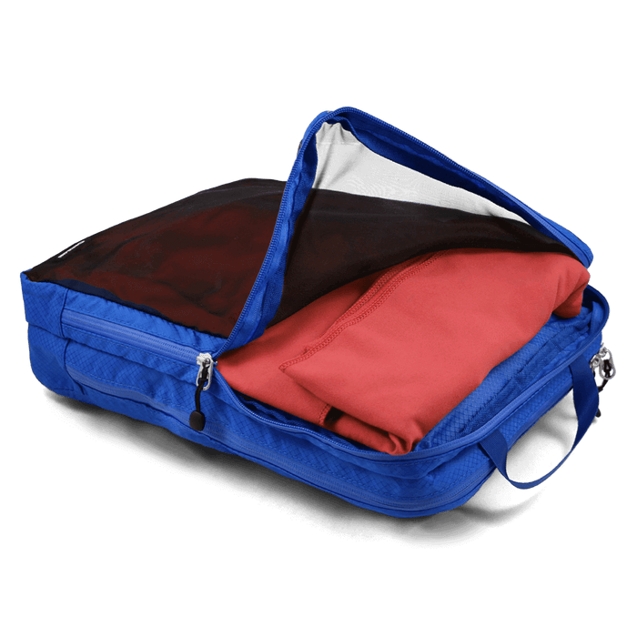 Blue Coghlan's Wet Dry Bag with visible compartments, holding red garment, showing double zippers and mesh front for breathability.