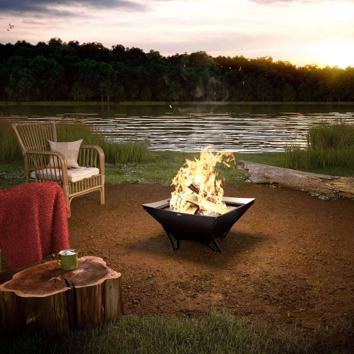 Drolet Nordet Fire Pit by a serene lakeside at sunset, perfect for outdoor gatherings and campfires.