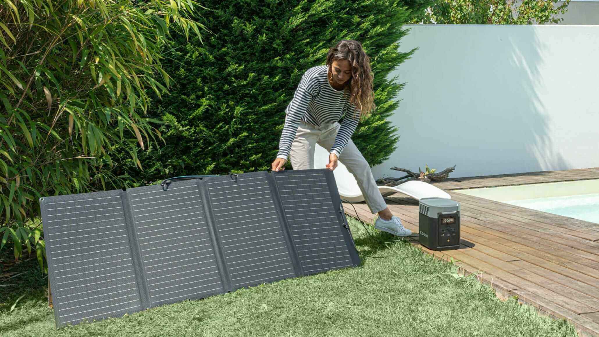 Woman setting up EcoFlow DELTA 2 Portable Power Station with solar panel, perfect for eco-friendly energy by Cabin Depot.