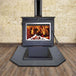 Englander 15-W03 wood stove with blower on a hearth, showcasing a burning fire, ideal for heating large spaces.