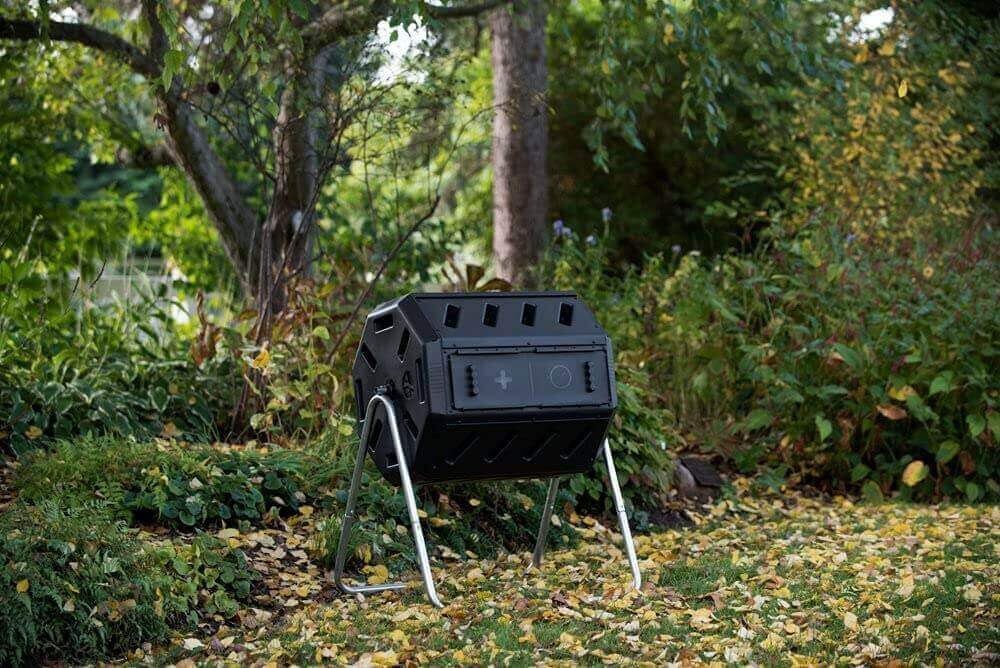 FCMP Outdoor Dual Chamber Tumbling Composter by Cabin Depot in a garden setting