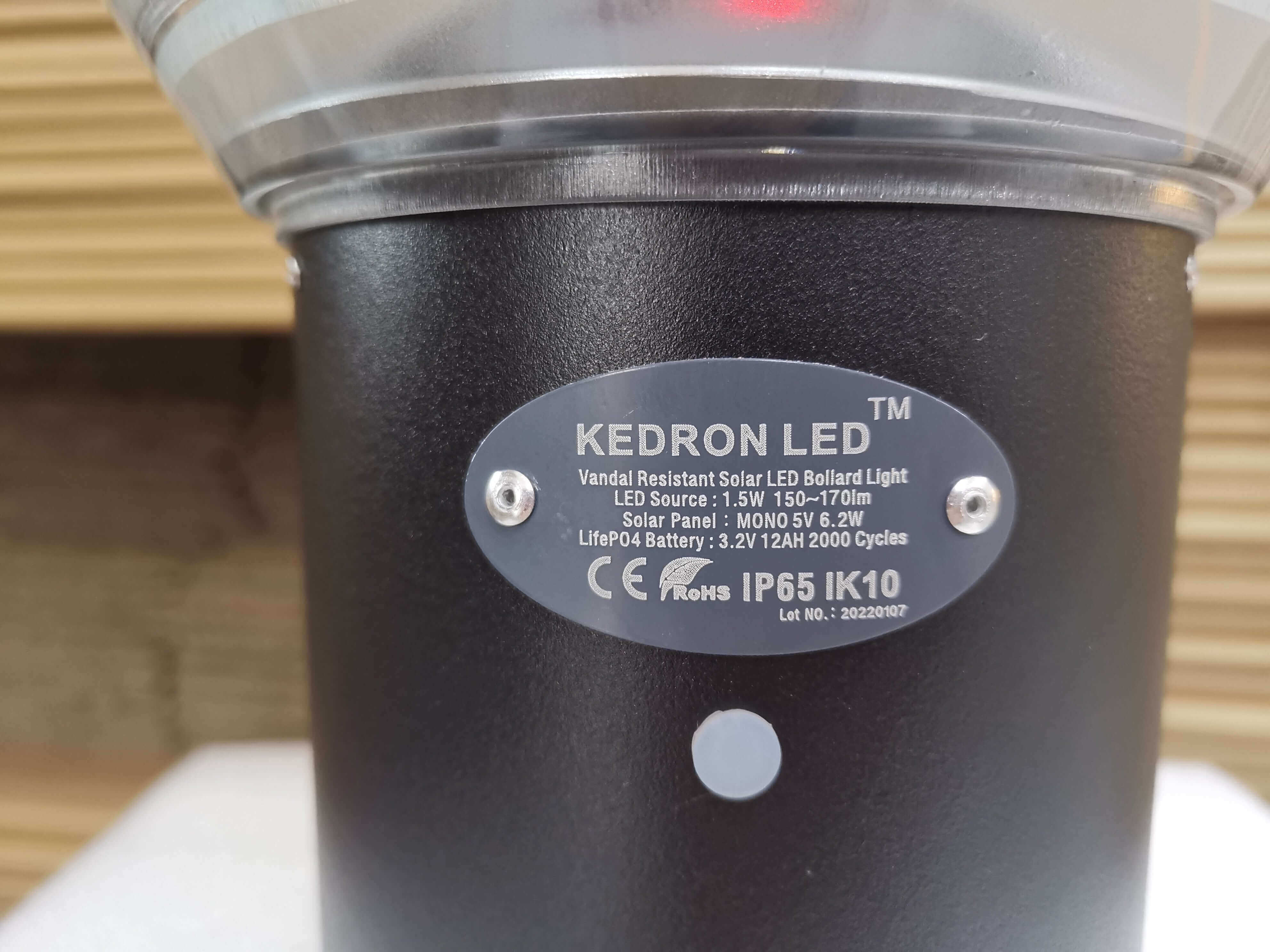Close-up of Kedron 90cm LED Solar Bollard Light's label details from Cabin Depot, highlighting its vandal-resistant features.