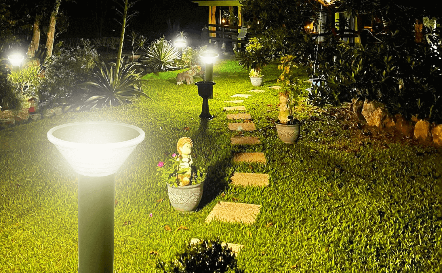 Kedron 90cm LED Solar Bollard Light illuminating a pathway in a garden setting, available at Cabin Depot.
