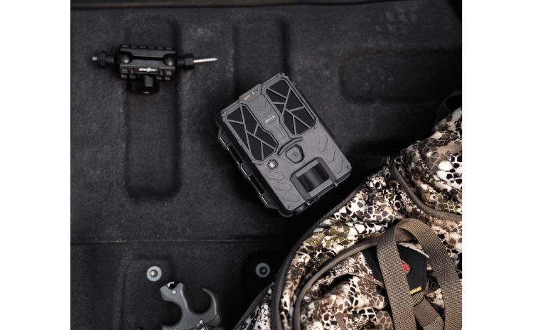 Spypoint FORCE-48 Trail Camera with easy setup configuration screen in a rugged outdoor setting.