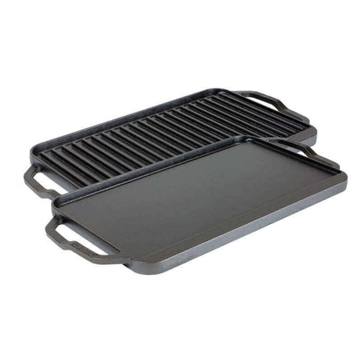 Reversible Lodge cast iron double burner grill/griddle with lifted handles and drip tray, perfect for versatile cooking.