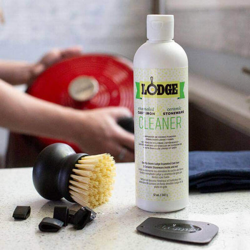 Lodge Enameled Cast Iron and Stoneware Care Kit with cleaner, brush, scraper, and pot protectors on a kitchen countertop.