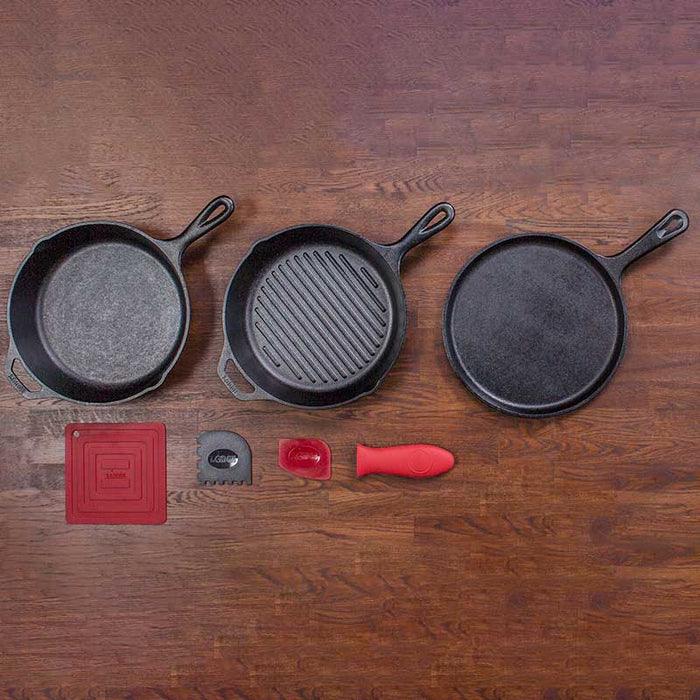 Lodge Essential Pan Set 6 Piece with cast iron skillets and accessories on wooden surface