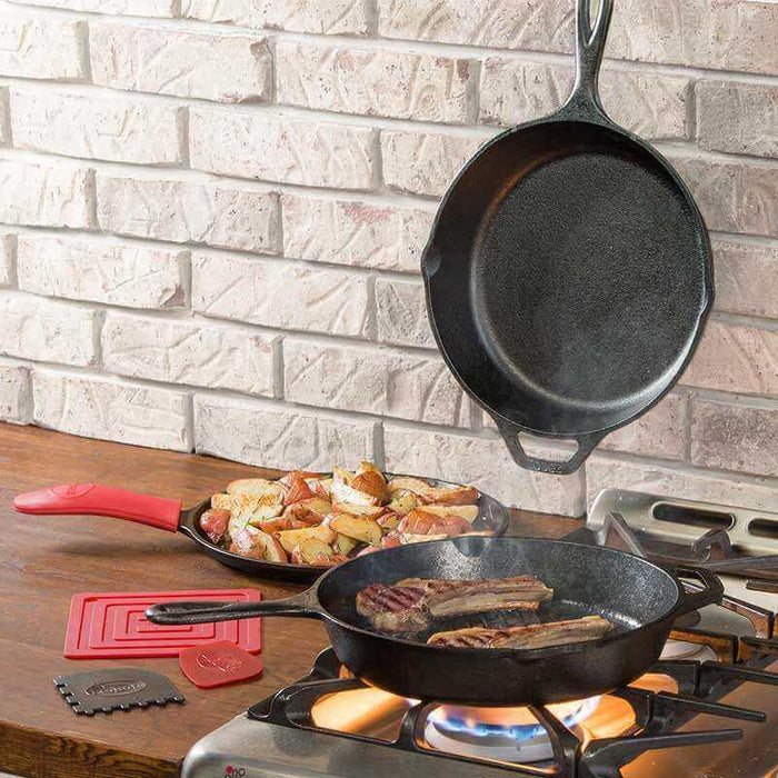 Lodge Essential Pan Set 6 Piece cooking steaks and potatoes on a stovetop, showcasing seasoned cast iron durability and performance.