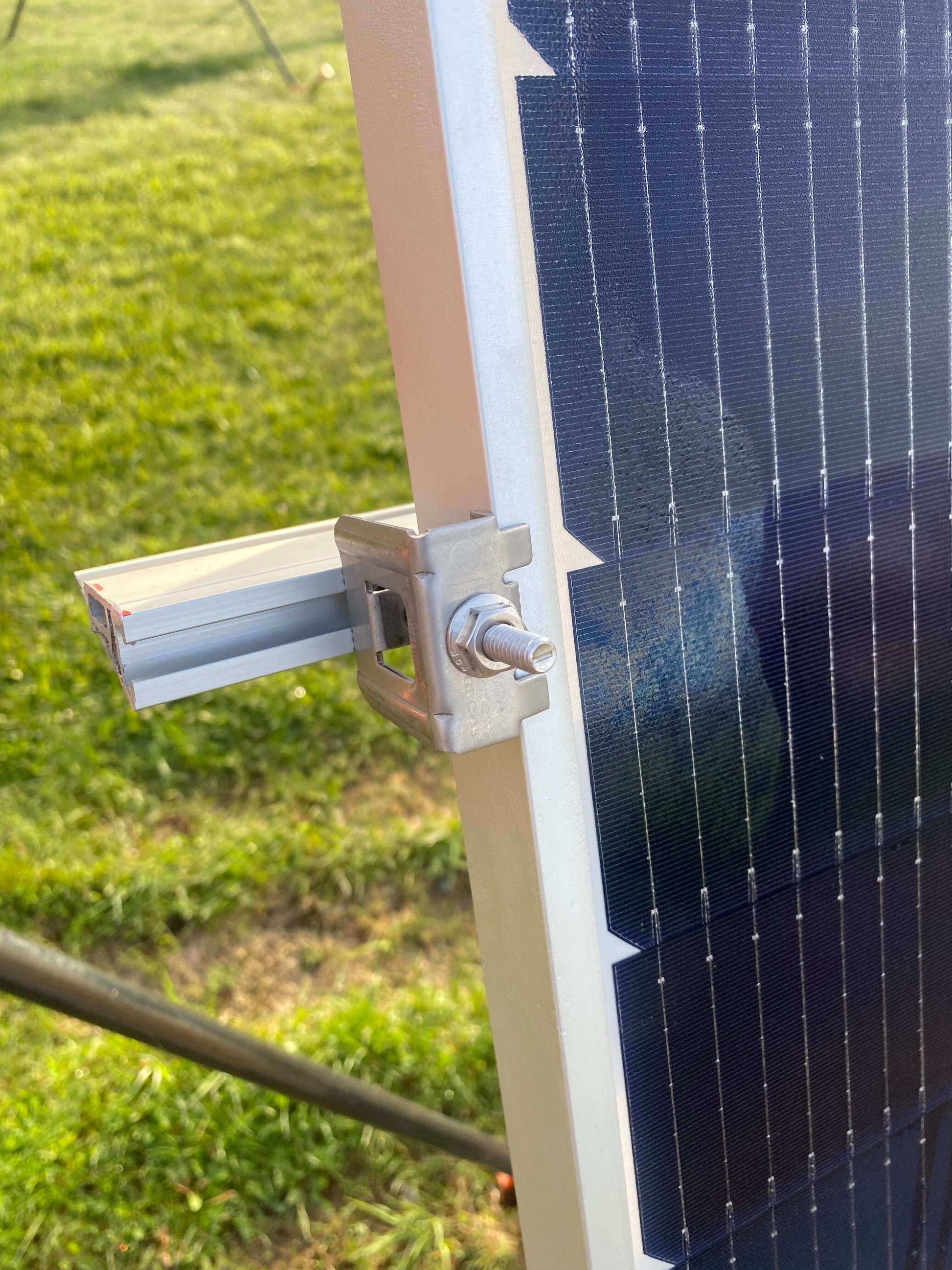 Close-up of Trifecta Ground Mount Panel Adapter Kit by Cabin Depot with solar rail and bracket installation.