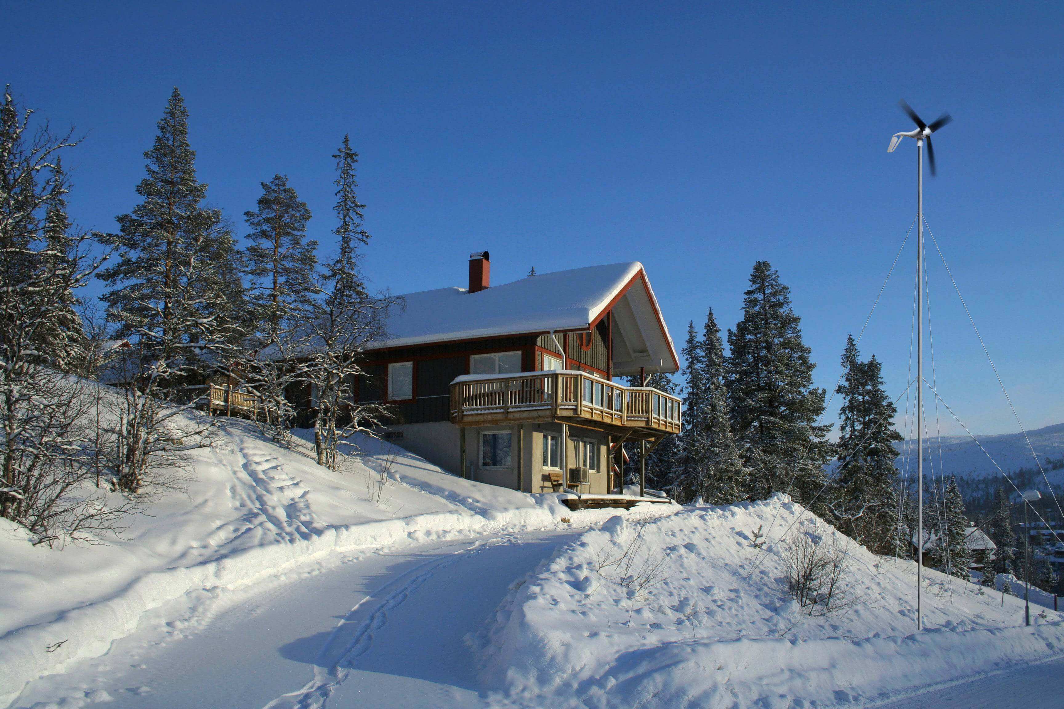 Cabin with AIR 40 micro-wind turbine in snowy landscape for efficient off-grid power by Cabin Depot