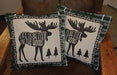 Pair of tapestry pillows with moose design and "Life is Better in the Woods" text, perfect for cabin decor.