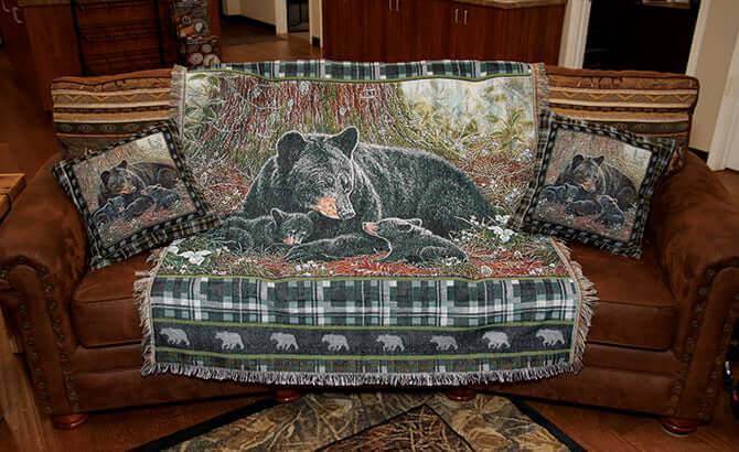 Bear-themed tapestry throw and matching pillows on a brown sofa in a cozy living room setting.