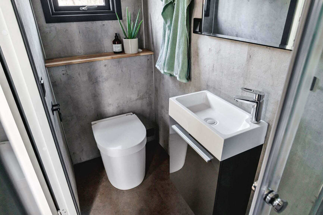 Compact bathroom with Separett Tiny 1271 Toilet next to modern sink in small space. Ideal for tiny houses and RVs.