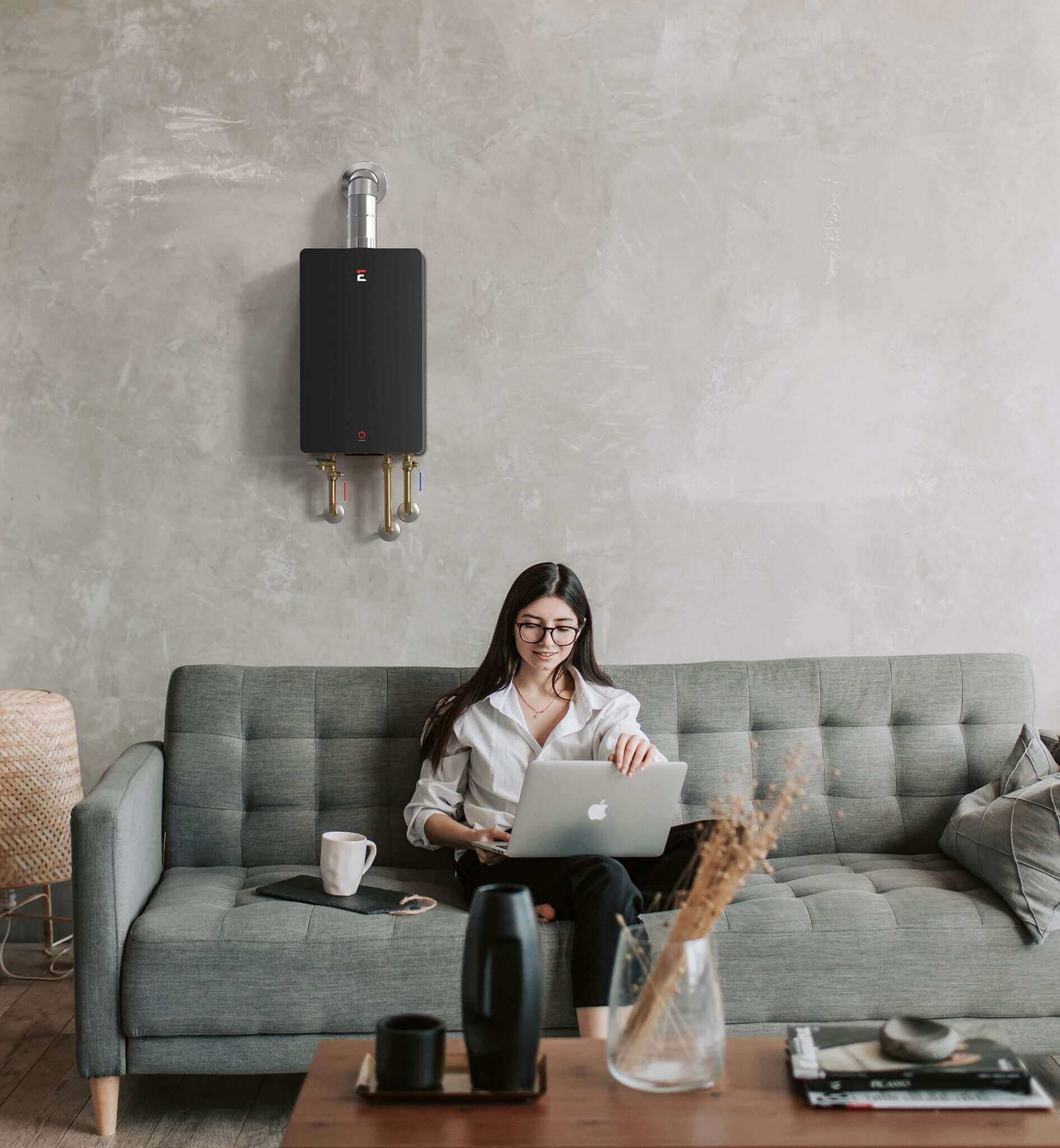 Woman using laptop in living room with Eccotemp 4.5 GPM SmartHome tankless water heater, available at Cabin Depot.