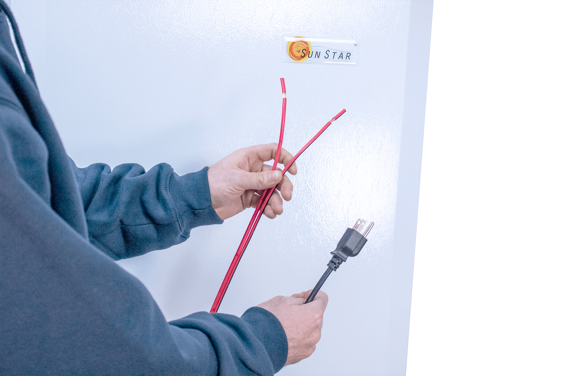 Person connecting cables to SunStar solar refrigerator, highlighting Cabin Depot's solar-powered appliance setup.