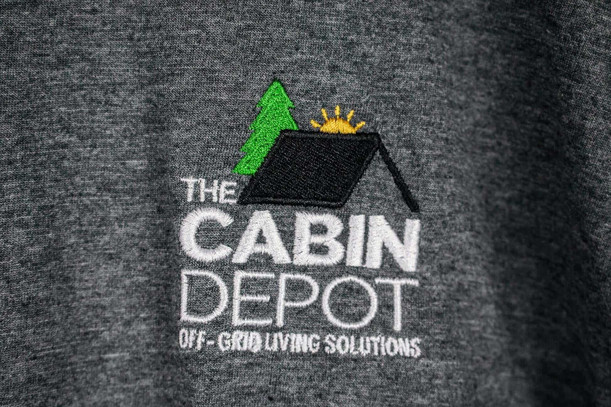 Cabin Depot logo embroidered on a heathered hoodie, showcasing off-grid living solutions.