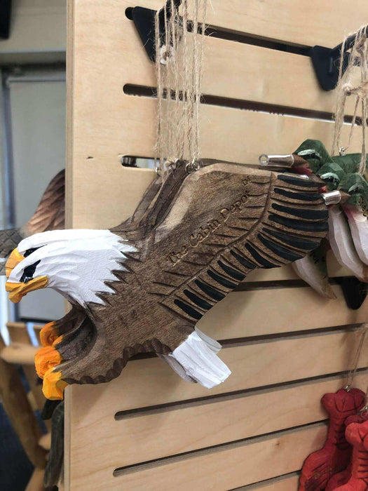 Handcrafted wooden eagle ornament by The Cabin Depot hanging on display.