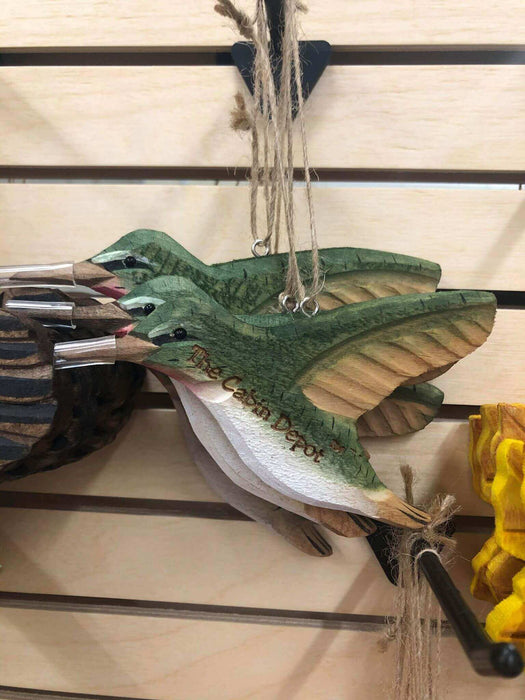 Handcrafted wooden bird ornaments from The Cabin Depot hanging on display, showcasing natural green and brown tones.