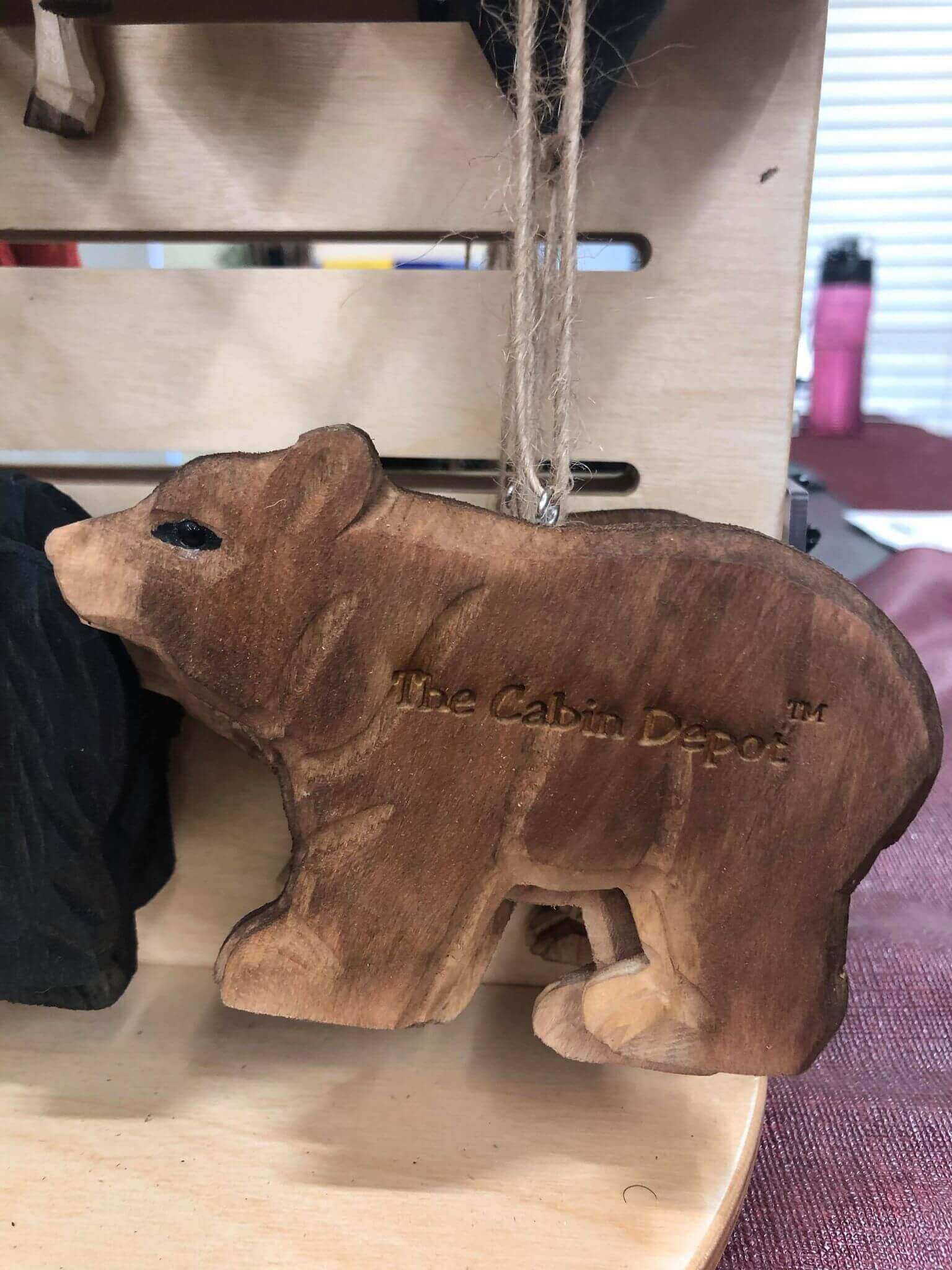 Handcrafted NWL wooden bear ornament by The Cabin Depot on display. Perfect for rustic decor, showcasing natural wood craftsmanship.