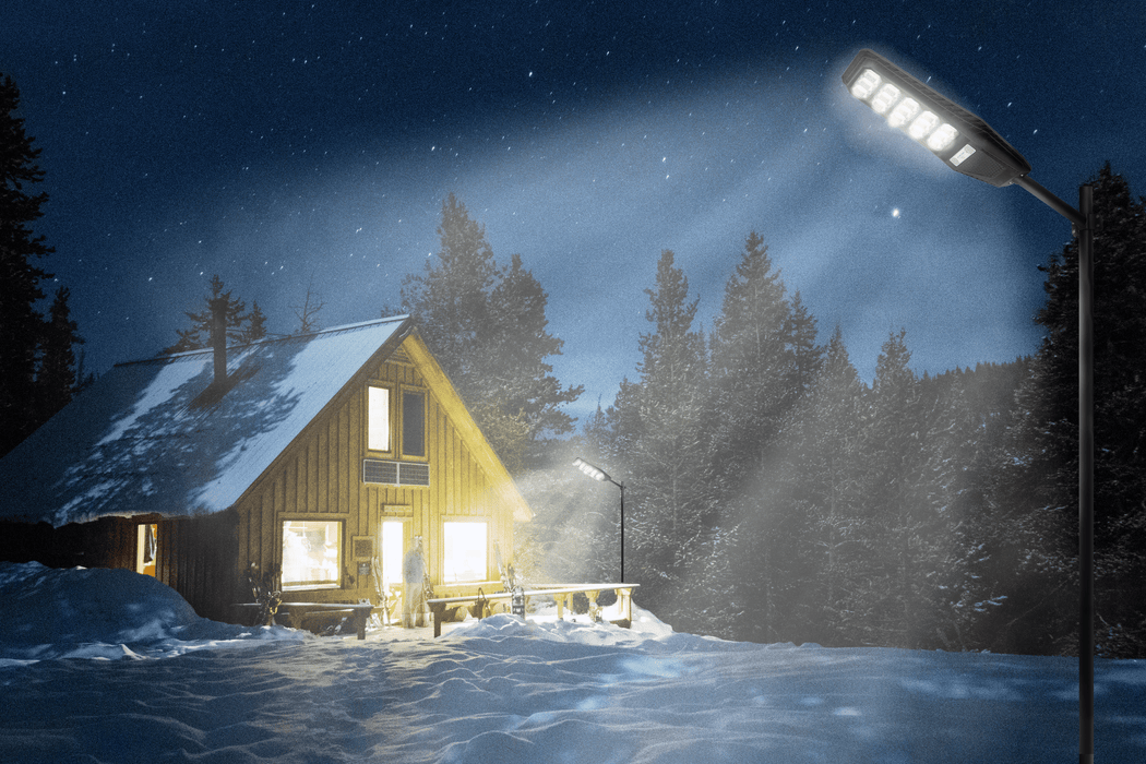 Intrepid Pioneer 100W Solar Street Lamp illuminating a snowy cabin at night, showcasing its powerful LED lighting in a winter setting.