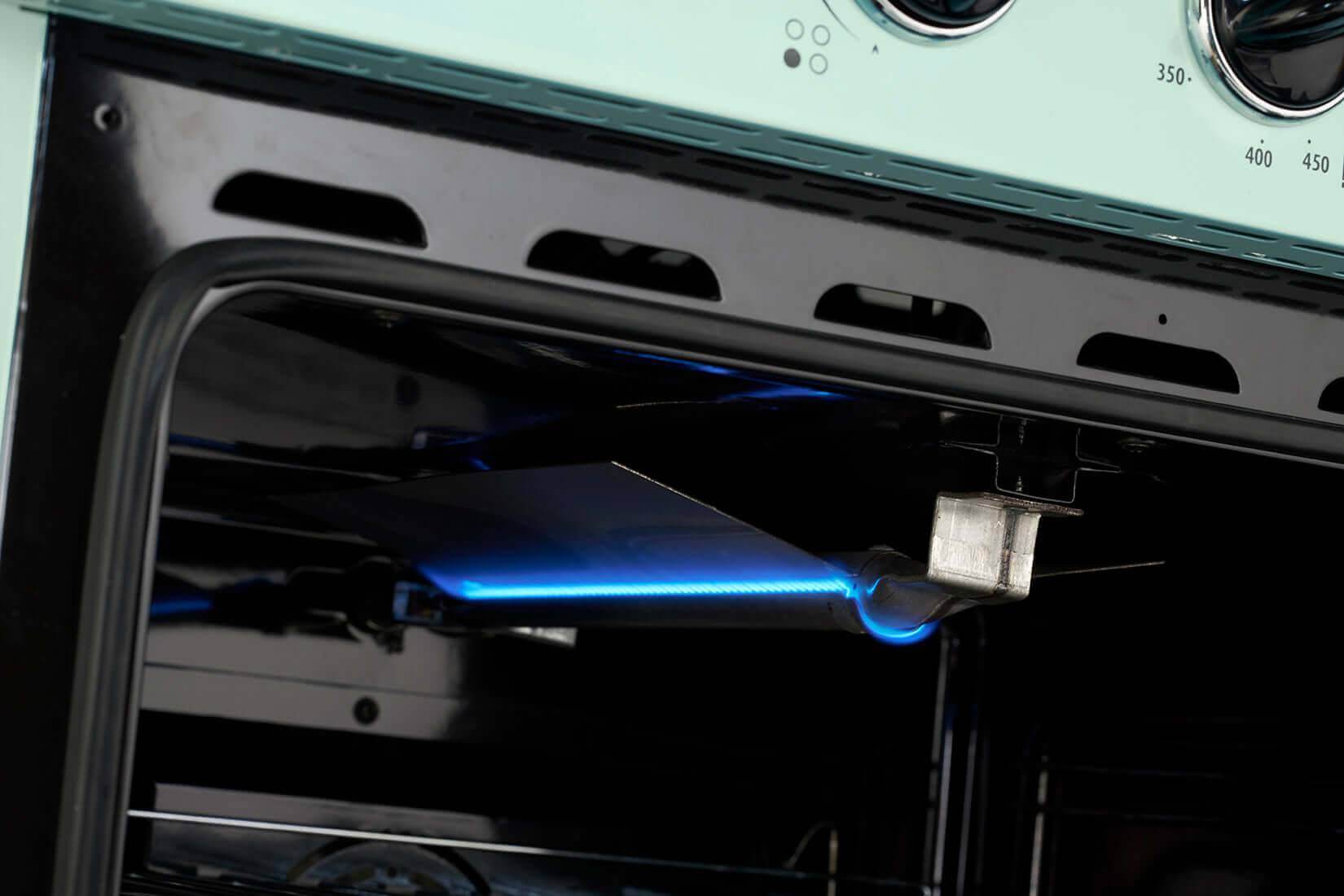 Close-up of Unique 30" Classic Retro Propane Range igniting, offered by Cabin Depot, showcasing 1950s style and off-grid functionality.