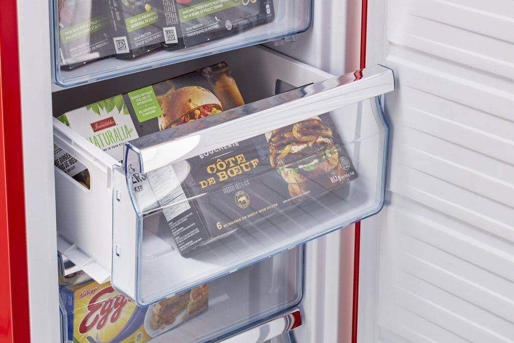 Interior view of Unique 6 Cu/Ft Retro AC Upright All Freezer with organized frozen food, available at Cabin Depot, energy-efficient and stylish.