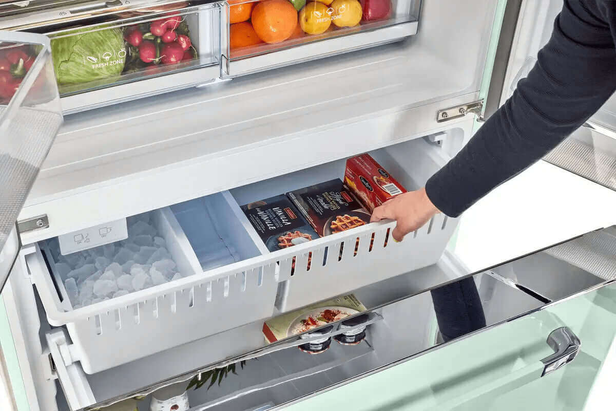 Opening a 21.4 Cu/Ft French door refrigerator drawer showing organized frozen foods and ice storage, available at Cabin Depot.