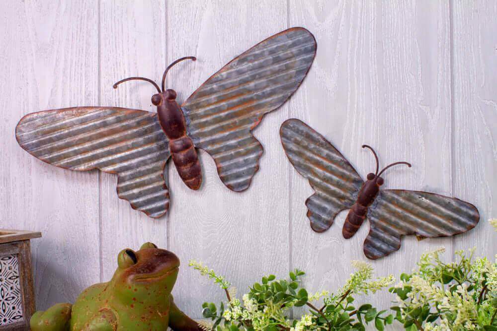 Galvanized butterfly hangers in garden setting, perfect for indoor or outdoor decorative use, featuring organic tin design.