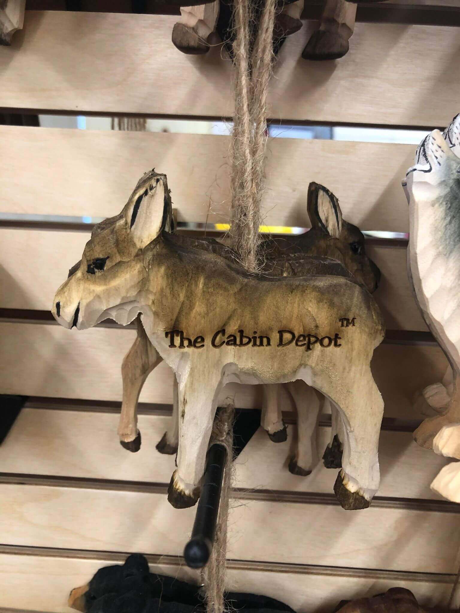 Handcrafted NWL wooden ornament of a donkey from The Cabin Depot displayed on shelves.