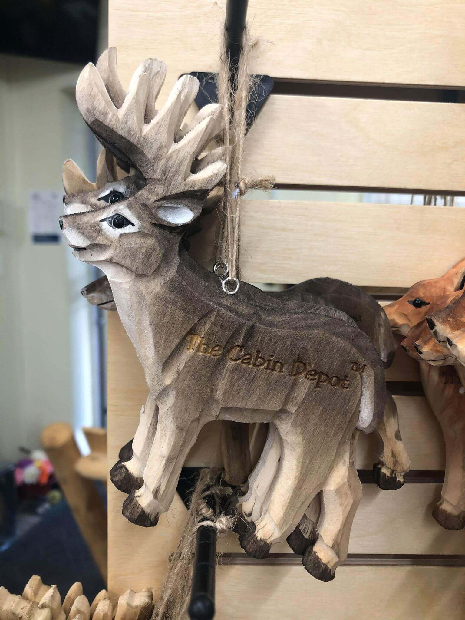 NWL hand crafted wooden deer ornament by The Cabin Depot, displayed on a wooden rack, perfect for rustic decor.