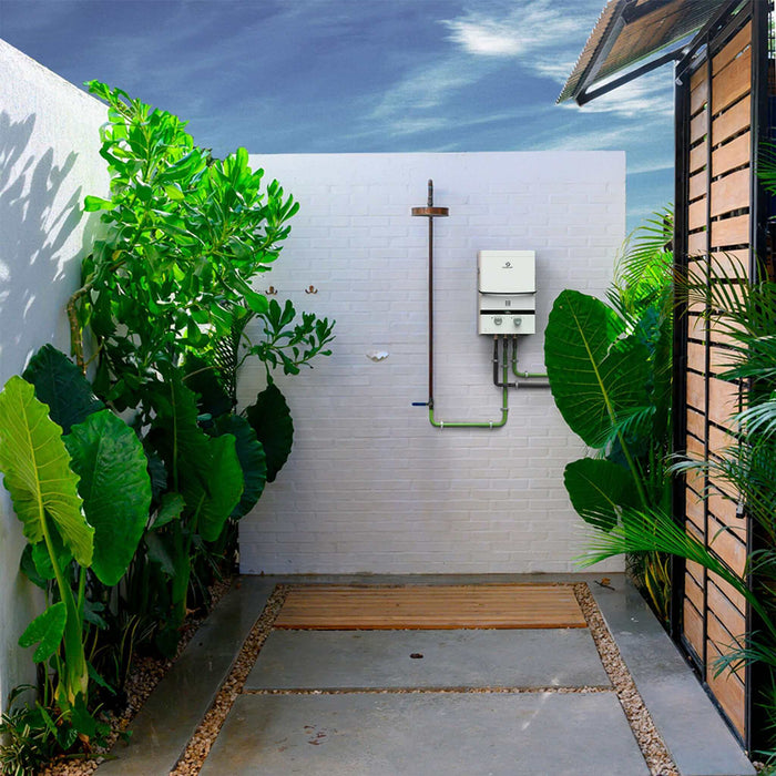 Outdoor shower area with Eccotemp EL7 Luxe tankless water heater, surrounded by greenery and modern design features.