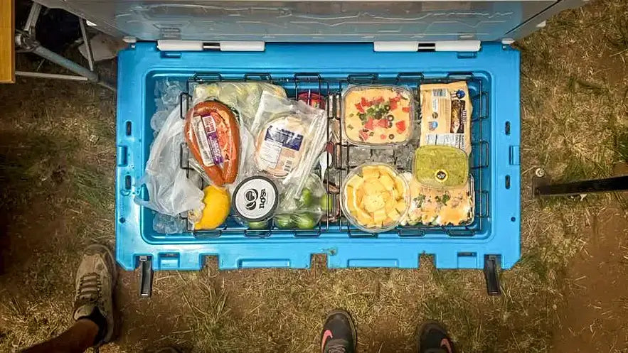 Canyon Coolers 55QT Outfitter Baskets organizing perishables, keeping them out of ice. Available at Cabin Depot. Ideal for camping trips.