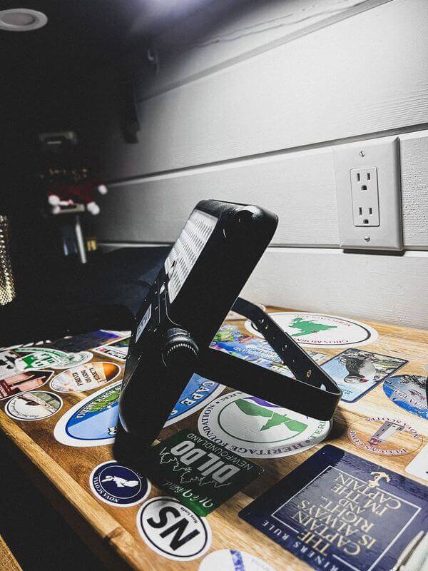 Kedron 10W LED solar light with adjustable bracket from Cabin Depot on a decorated wooden surface.