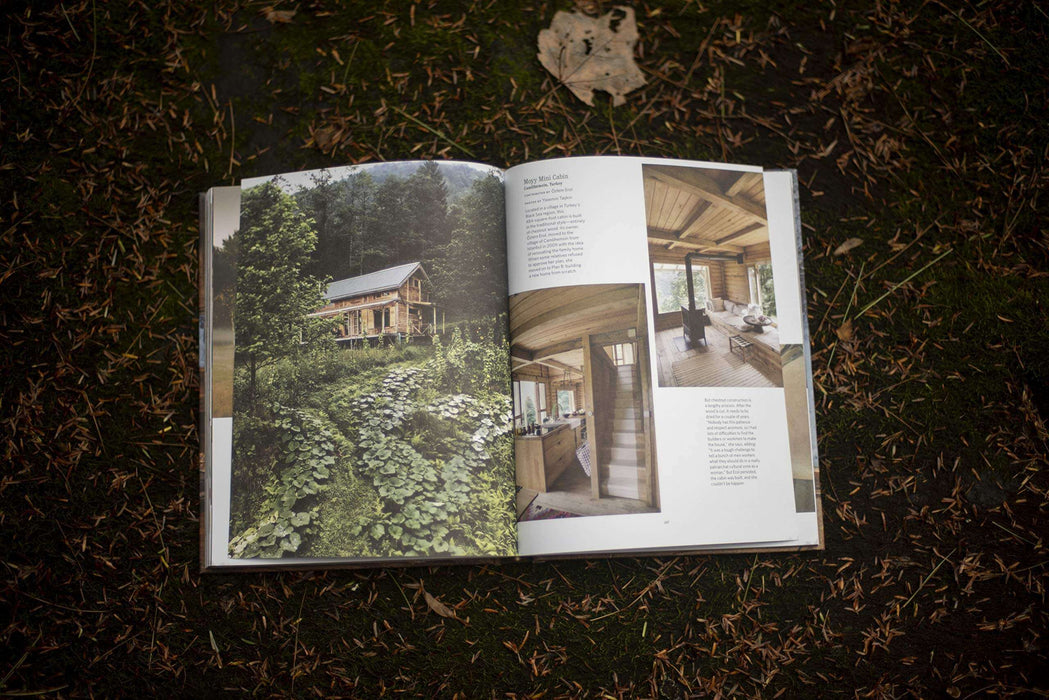 Open page of Cabin Porn Inside book showcasing tranquil cabin interiors and lush forest setting on a natural background.