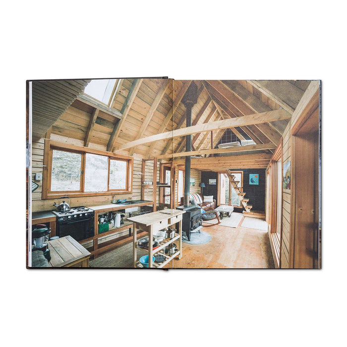 Open book showing interior of a cozy wooden cabin with natural light and rustic design.