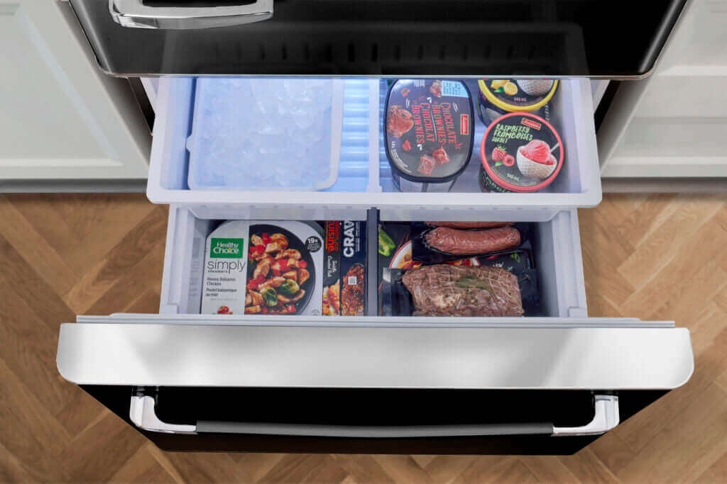 Open freezer drawer of 18 cu. ft. retro bottom mount refrigerator filled with food, available at Cabin Depot. ENERGY STAR certified for efficiency.